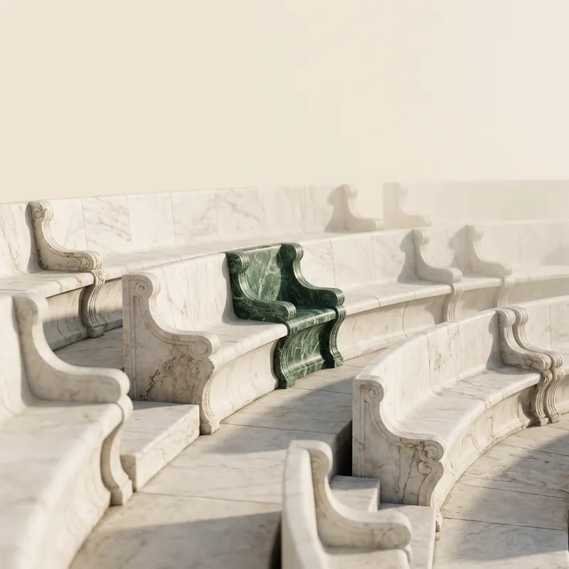 A row of empty marble seats in an ancient theatre, one of them in green marble.